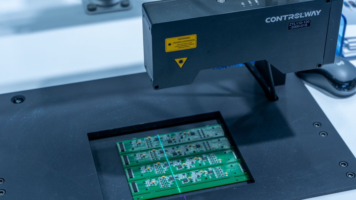 Automated inspection system scanning a panel of assembled PCBs at end of line