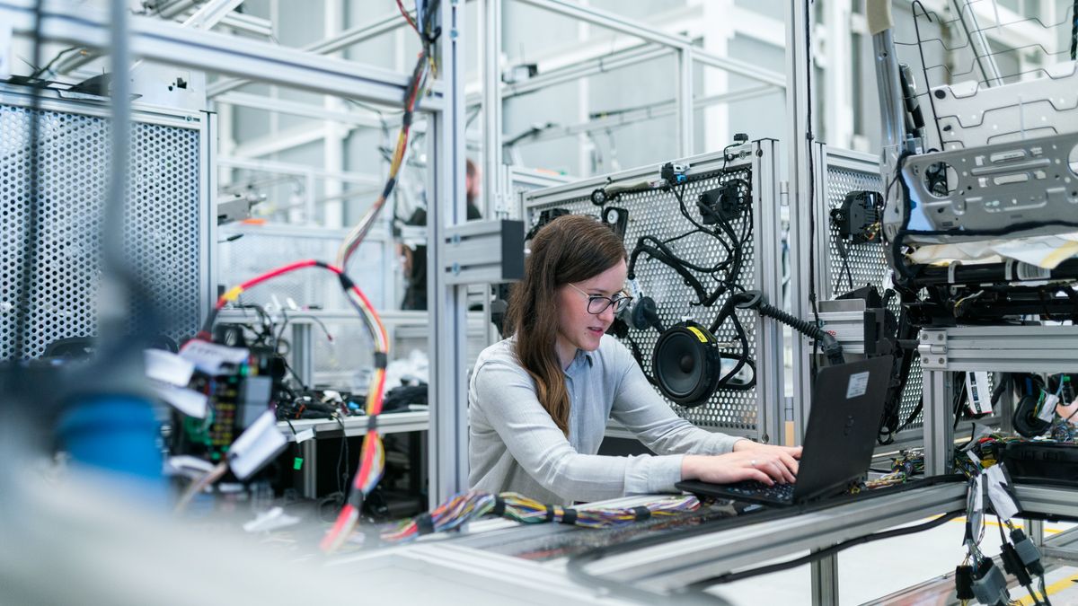 Engineer at a programming station with a wired test board in an industrial lab